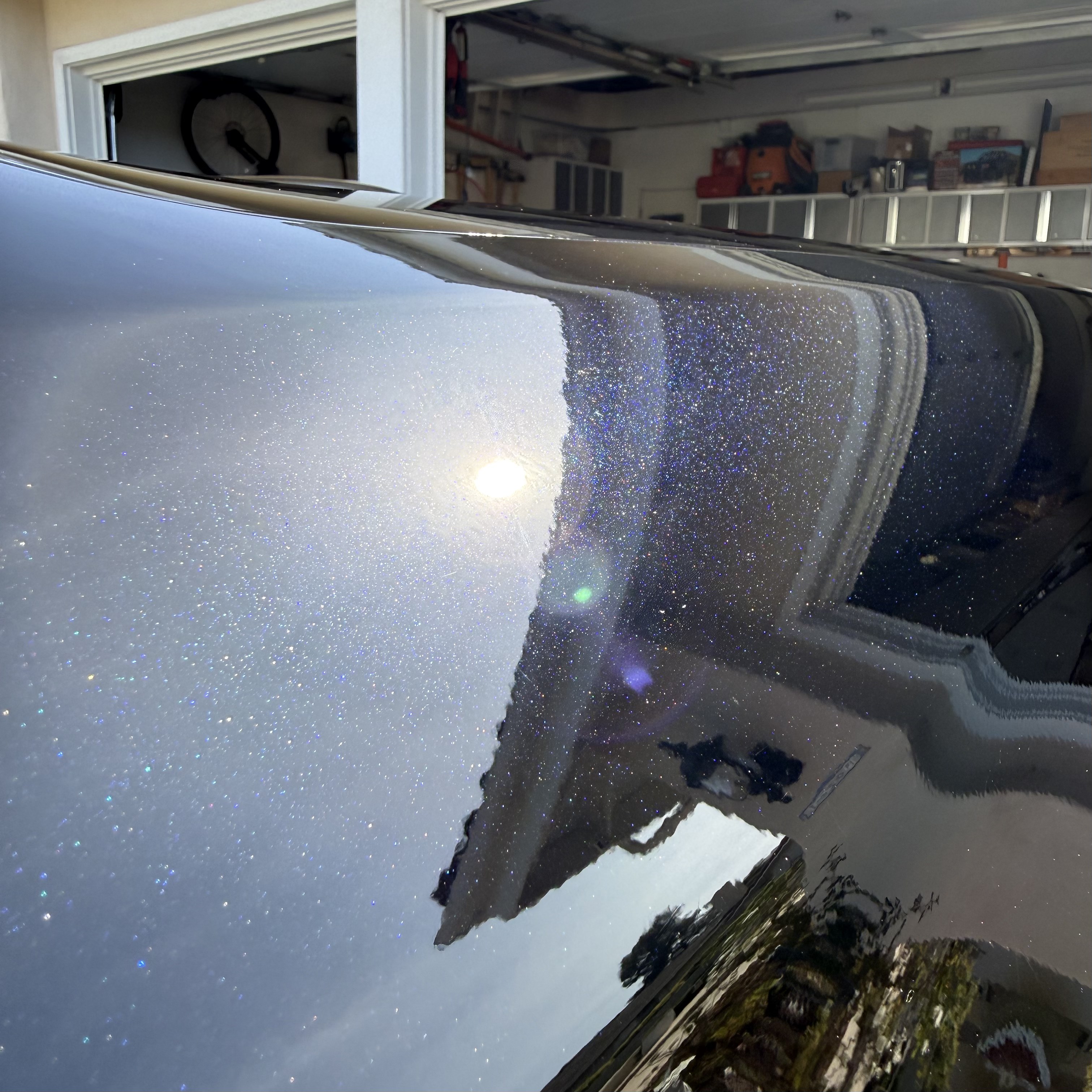 After: mirror-gloss finish on dark blue Porsche after paint correction